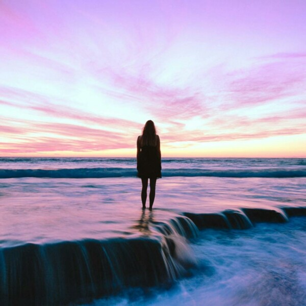 Silhouette Photography of Woman Standing on Seashore during Golden Hour