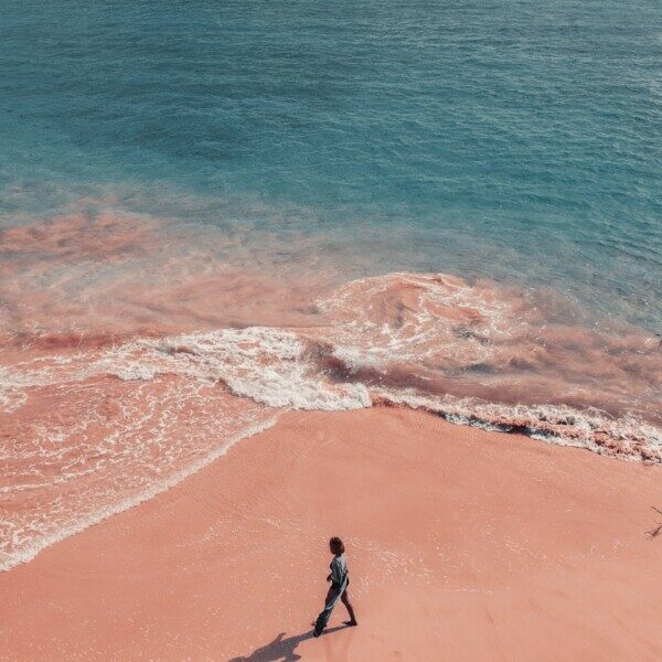 a person walking on a beach near the ocean